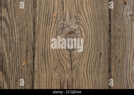 Weathered and worn cracked and a knot with textures of a section of an old wooden planking on a bridge closeup outdoors for flat-lays backgrounds and Stock Photo