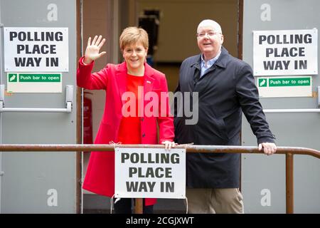 Uddingston, Scotland, UK.  Pictured: (left) Nicola Sturgeon - First Minister of Scotland and Leader of the Scottish National Party (SNP), seen with her husband, (right) Peter Murrell CEO of the Scottish National Party (SNP), visiting her local polling station to cast her vote in the European Elections for the SNP to keep Scotland in Europe. Credit: Colin Fisher/Alamy Live News. Stock Photo