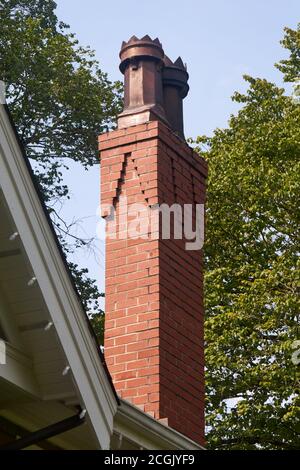 Decorative chimney topper or chimney pots on the red brick chimney of a house Stock Photo