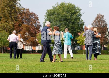 Senior couples dancing ballroom steps in the park during Covid. Elderly males and females dancing in hold in Priory Park, Southend on Sea, Essex, UK Stock Photo