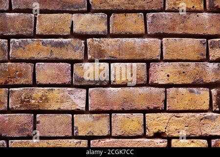 Victorian yellow brickwork wall textured background with mortar eroded away between bricks Stock Photo