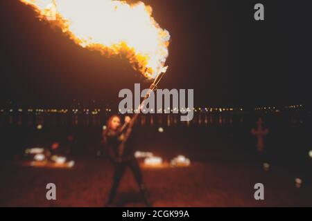 Group of fire artists fakir perform amazing show at night with flamethrowers, fire dancers, chain of fire, extreme flame breathing Stock Photo