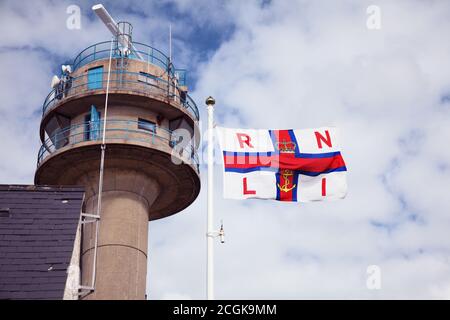 Royal National Lifeboat Institution RNLI flag flying at Calshot Tower Lookout station run by National Coastwatch Institute (NCI). Stock Photo