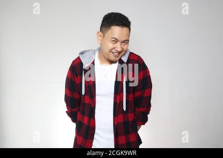 Portrait of funny young attractive cute Asian man smiling shy happily Stock Photo