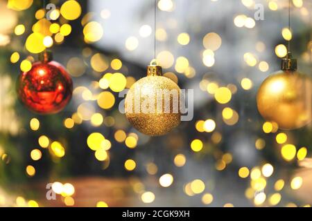 Gold and red balls on a blurred holiday background with many lights. Christmas and New Year background. Stock Photo