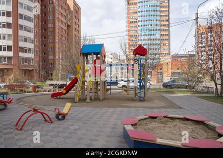 Children's playground with a sandbox and swings in the courtyard of the houses in the city of Krasnoyarsk. Krasnoyarsk Territory, Russia. Stock Photo