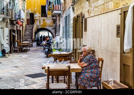 BARI, ITALY - SEPTEMBER 1, 2020: housewives making orecchiette in the streets of Bari Vecchia Stock Photo