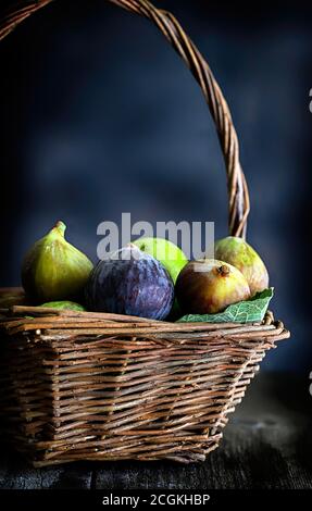 Fresh figs in wicker basket. Closeup. Blurry background. Stock Photo