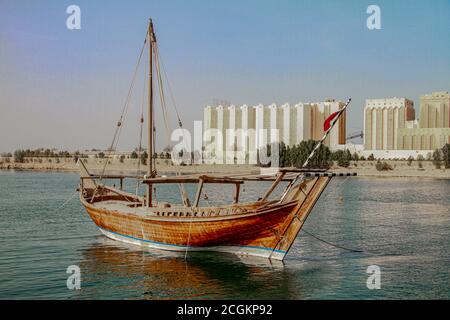 Traditional boats called Dhows are anchored in the port near Museum of Islamic Art Park Stock Photo