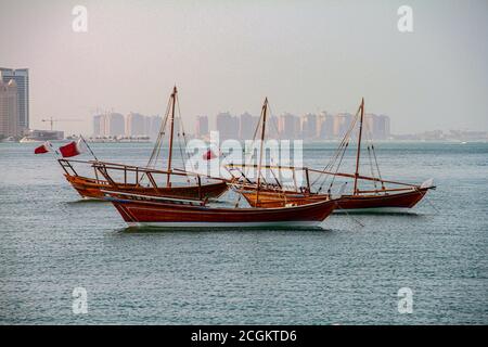 Traditional boats called Dhows are anchored in the port near Museum of Islamic Art Park Stock Photo