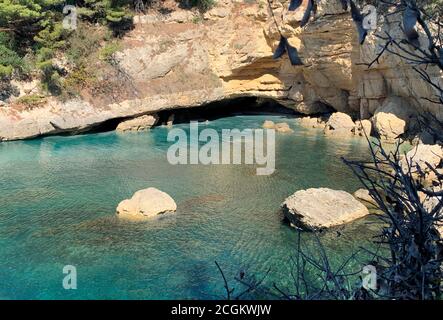 Scenic rocky beach on Adriatic coast of Montenegro. Picturesque rocks, sea cave, clear blue  Mediterranean sea. Calm turquoise water. Summer vacation. Stock Photo