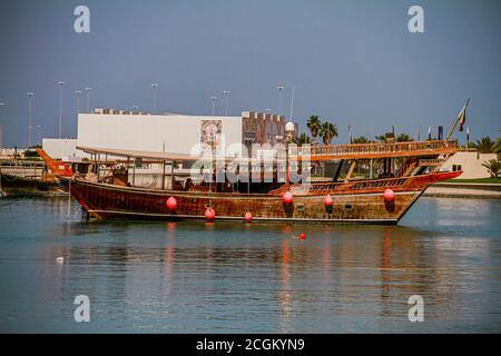 Traditional boats called Dhows are anchored in the port near Museum of Islamic Art Park Stock Photo