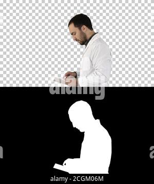 Portrait of male doctor walking and using digital tablet, Alpha Stock Photo