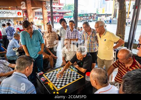 Chinatown, Singapore - 11 2018: Old men play Xiangqi, chinese chess Stock Photo