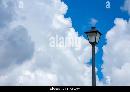 Horizontal shot of a lamppost against a blue cloudy sky. Stock Photo