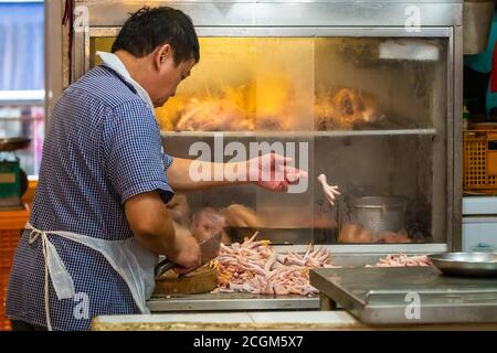 Singapore - 11 2018: Butcher at work at Tekka Indian market Stock Photo