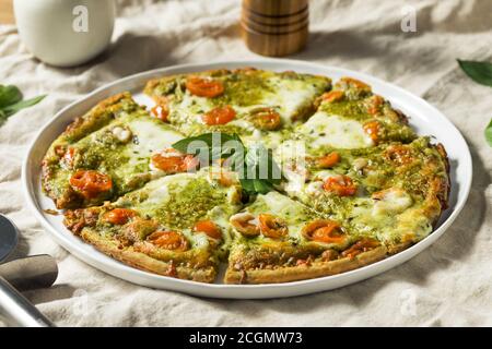 Homemade Green Pesto Pizza with Mozzarella and Tomatoes Stock Photo