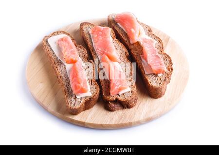 Smoked salmon sandwiches with butter on wooden board, isolated on white background. close up. Stock Photo