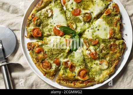 Homemade Green Pesto Pizza with Mozzarella and Tomatoes Stock Photo