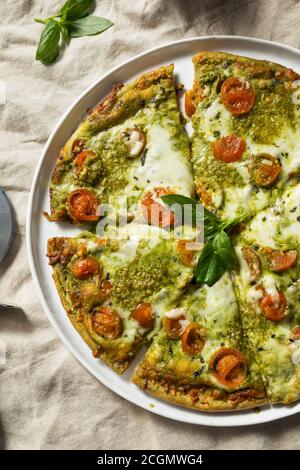 Homemade Green Pesto Pizza with Mozzarella and Tomatoes Stock Photo