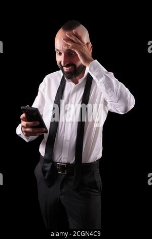 Surprised hispanic man reading unbelievable news on his smartphone Stock Photo