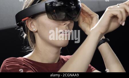 Girl standing in virtual reality glasses and talking to someone. Stock Photo