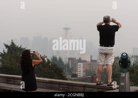 Seattle, USA. 11th Sep, 2020. People visiting the normally scenic Kerry Park, viewing the city skyline now blanketed with a plume of Wildfire smoke covering the Pacific Northwest. Seattleites are adjusting to a new normal of smokey summers. Wildfires rage yearly now causing a dramatic drop in air quality from the normally crisp clean Washington air. Credit: James Anderson/Alamy Live News Stock Photo