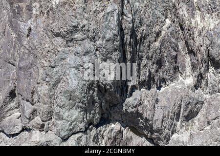 A close-up of a gray rock with raised ridges, honed by water and wind for centuries. Background for wallpaper, post or illustrations in social network Stock Photo
