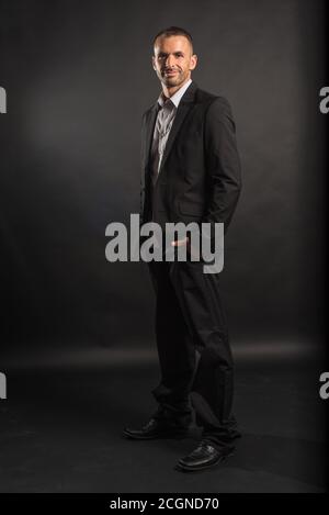 Handsome man in suit. Full body. Black background. Stock Photo