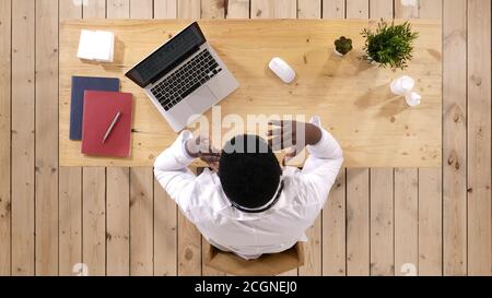 Young african american doctor suffering from headache desperate Stock Photo