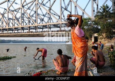 22.02.2011, Kolkata (Calcutta), West Bengal, India, Asia - People wash up at Mallick Ghat along the bank of the Hooghly River with the Howrah Bridge. Stock Photo