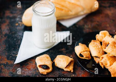 Nice breakfast - milk with croissants on black rustic surface Stock Photo