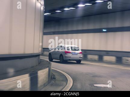 car moves in the lit tunnel on turning movement Stock Photo