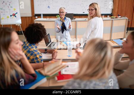 Female professor discussing a lesson with students at a lecture in amphitheatre Stock Photo