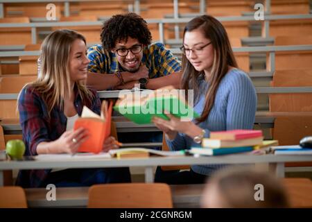 Students chatting about the lesson at an amphitheatre in break of a lecture Stock Photo