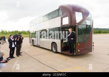 Boris Johnson Mayor of London revealing to the press a prototype of the New Bus for London which is undergoing trials at the Millbrook Proving Ground vehicle testing centre located at Millbrook, Bedfordshire. The bus late became know as New Routemaster and was nick named the Boris Bus.   The New Bus for London, is a hybrid diesel-electric double-decker bus operated in London, Designed by Heatherwick Studio and manufactured by Wrightbus, it is notable for featuring a 'hop-on hop-off' rear open platform similar to the original Routemaster bus design but updated to meet requirements for modern bu Stock Photo