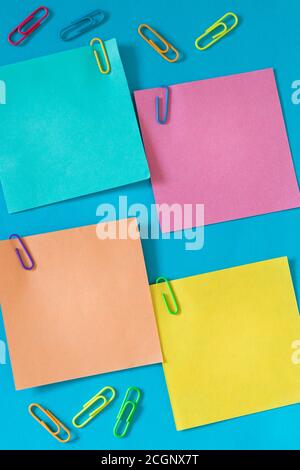 small colored sticky notes with office staples and space for text, Blue background Stock Photo