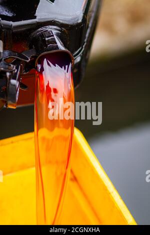 Red diesel being poured from a jerry can into a plastic container Stock Photo