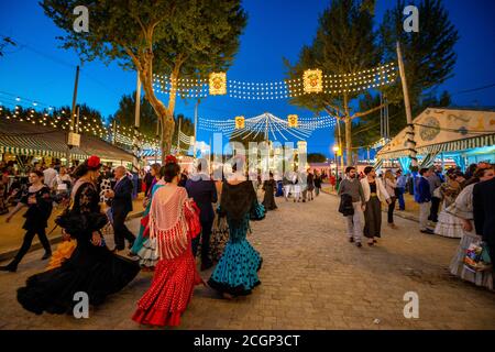 Spanish women with colorful flamenco dresses, evening mood, Feria de Abril, Sevilla, Andalusia, Spain Stock Photo