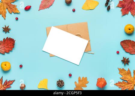 Thanksgiving autumn greeting card or invitation. Dried leaves, flowers, nuts, berries on blue background. Flat lay, mock up. top view with copy space Stock Photo