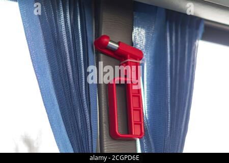 Red evacutation hammer in public transport. Equipment for braking window Stock Photo