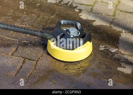 Cleaning the paving stones of the terrace with surface cleaner and high pressure cleaner Stock Photo