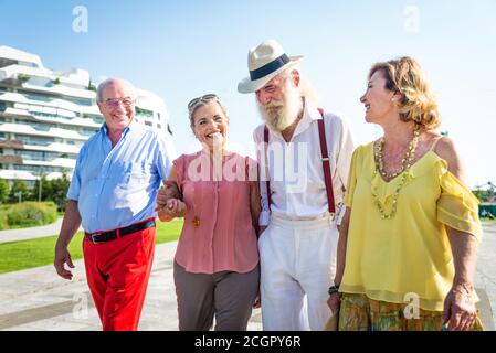 Group of youthful seniors having fun outdoors - Four pensioners bonding outdoors, concepts about lifestyle and elderly Stock Photo