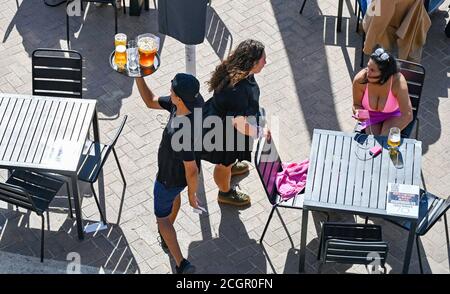 Brighton UK 12th September 2020 - Time to enjoy a beer on Brighton seafront on a sunny but breezy day as hot weather is forecast to spread across Britain over the next few days ..   : Credit Simon Dack / Alamy Live News Stock Photo