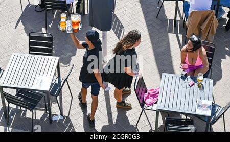 Brighton UK 12th September 2020 - Time to enjoy a beer on Brighton seafront on a sunny but breezy day as hot weather is forecast to spread across Britain over the next few days ..   : Credit Simon Dack / Alamy Live News Stock Photo