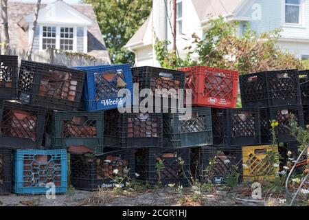 Empty milk crates piled up outdoors. Stock Photo