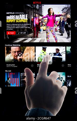 hand on touch screen tablet choosing a program on Netflix Stock Photo