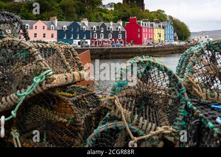 View of lobster pots and colourful buildings along waterfront at Tobermory harbour on Mull, Argyll & Bute, Scotland, UK