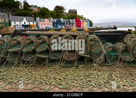 View of lobster pots and colourful buildings along waterfront at Tobermory harbour on Mull, Argyll & Bute, Scotland, UK