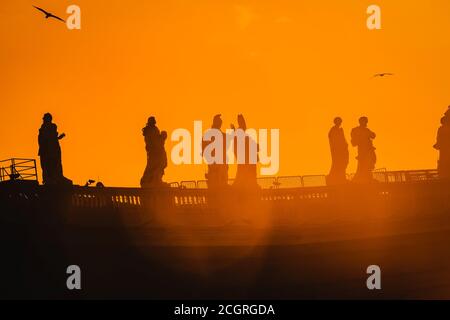 Sculptures of saints in Vatican, silhouette on the orange background Stock Photo